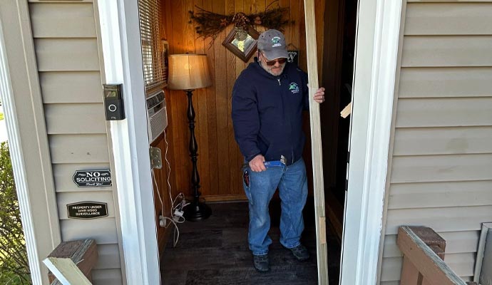A man is replacing a door