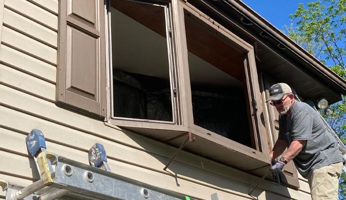 A person is installing window in residential house