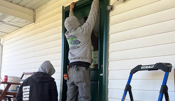 Two people installing front door