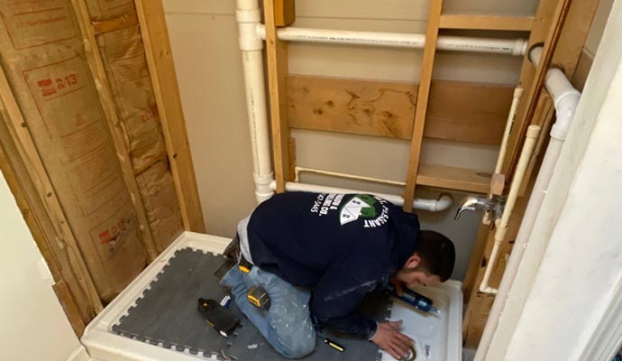 A person is installing shower base
