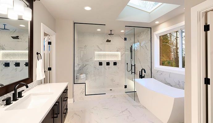 Modern bathroom renovation featuring a freestanding bathtub, glass shower and elegant finishes