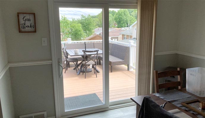 A sliding patio door provides a view of the outdoor deck from the dining area