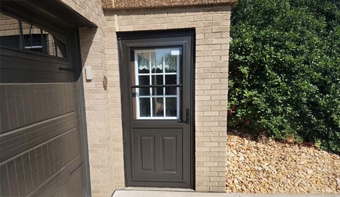 Black Spectrum Storm Door installed at the entrance of a residential property