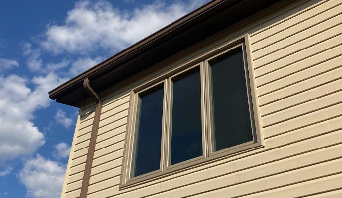 Beige house triple window installation
