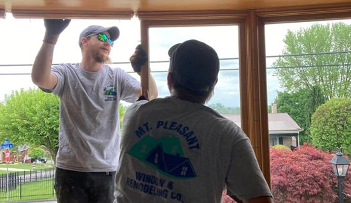 Two people are installing residential window